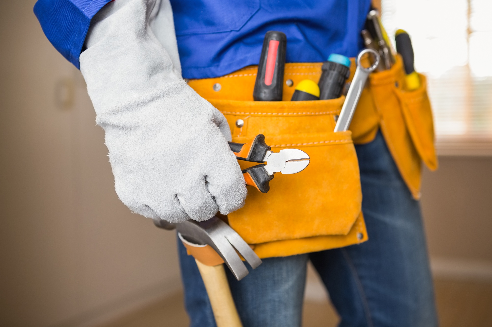 Close up of handyman in tool belt in a new house